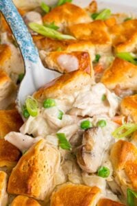 Fork lifting bite of chicken casserole with golden biscuit piece.