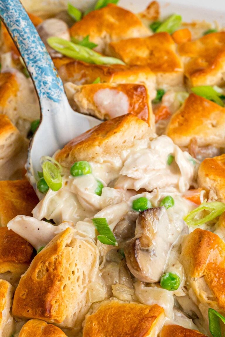 Fork lifting bite of chicken casserole with golden biscuit piece.