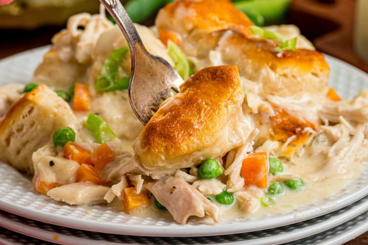 Serving of chicken and biscuits on white textured plate.