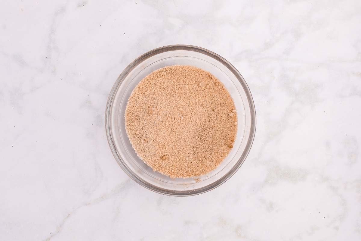 Glass bowl filled with cinnamon sugar mixture for coating churros.