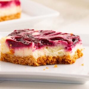 close up of of layered cheesecake bar, bite missing.