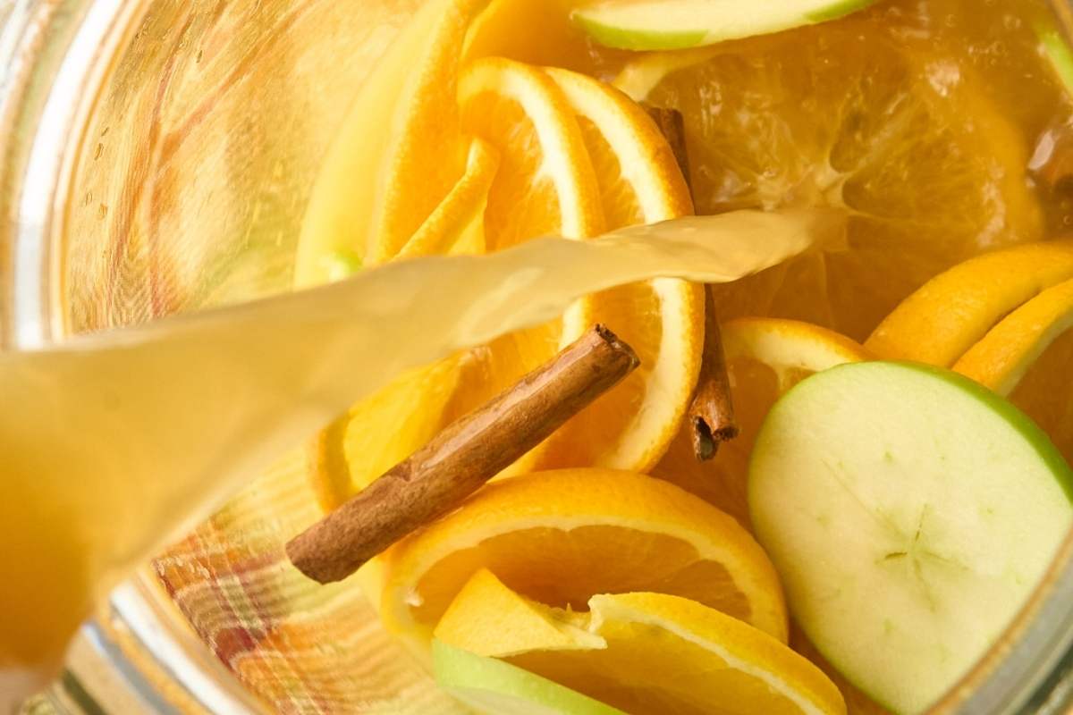 pouring cider over fruit.