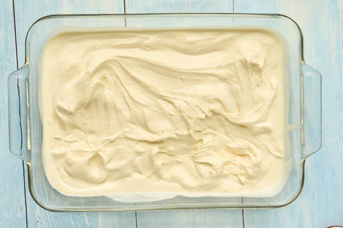 Ice cream mixture spread in rectangular glass baking dish.