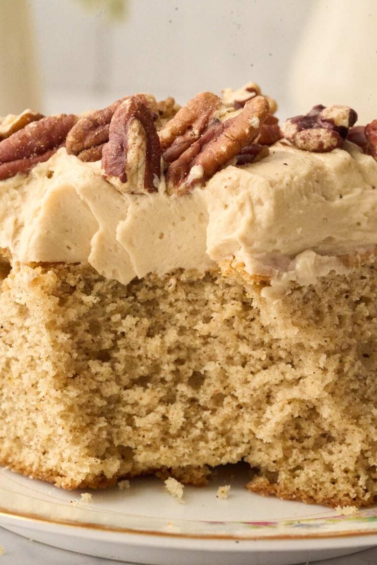 Close-up of spice cake slice showing fluffy texture and thick praline frosting.