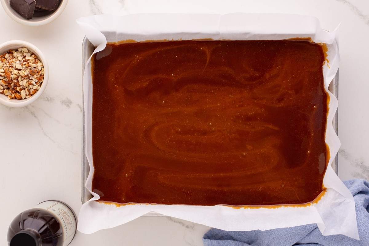 Freshly poured toffee cooling in a parchment-lined pan.