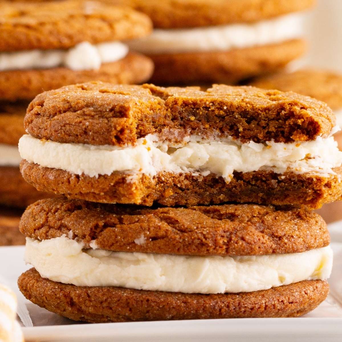 Stack of molasses sandwich cookies cut in half showing filling.