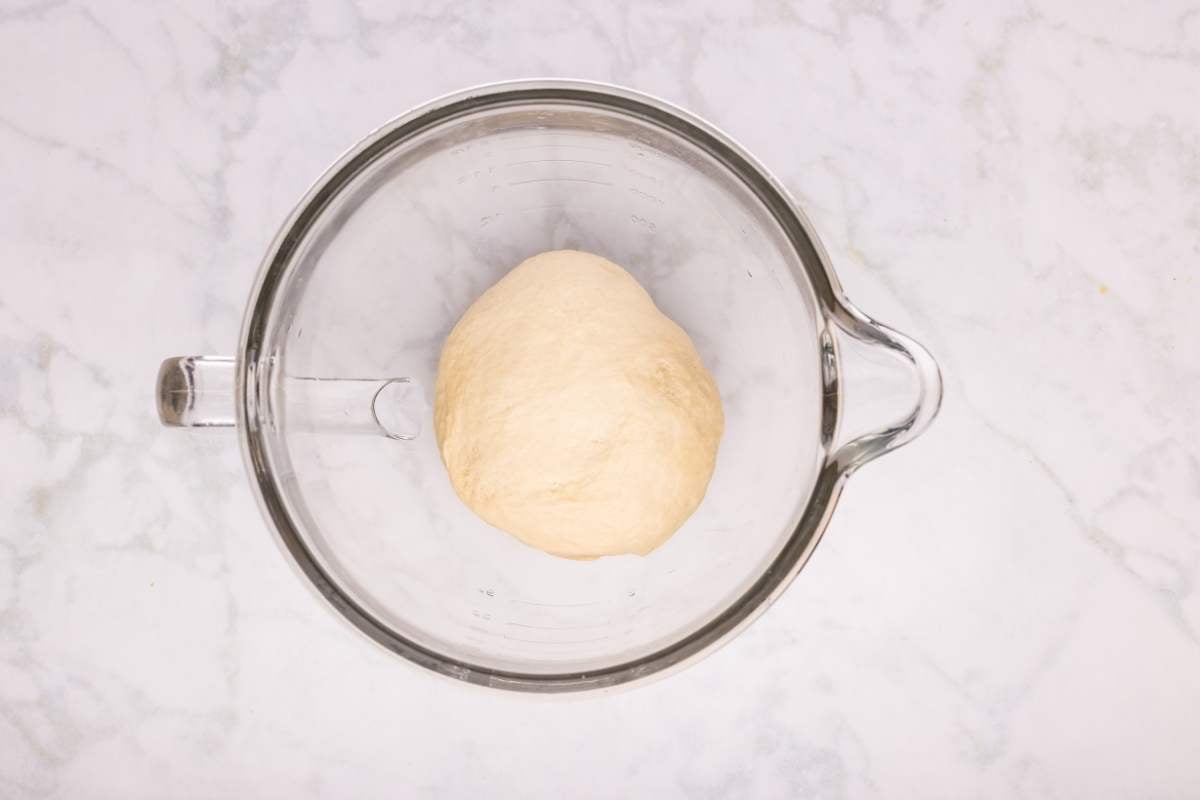 Ball of dough in a glass mixing bowl.
