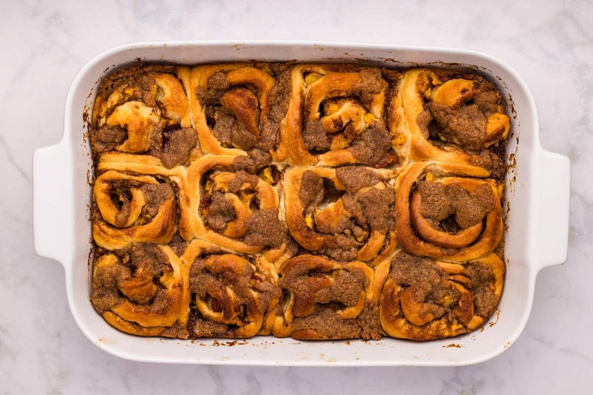 Baked cinnamon rolls in a white rectangular dish.