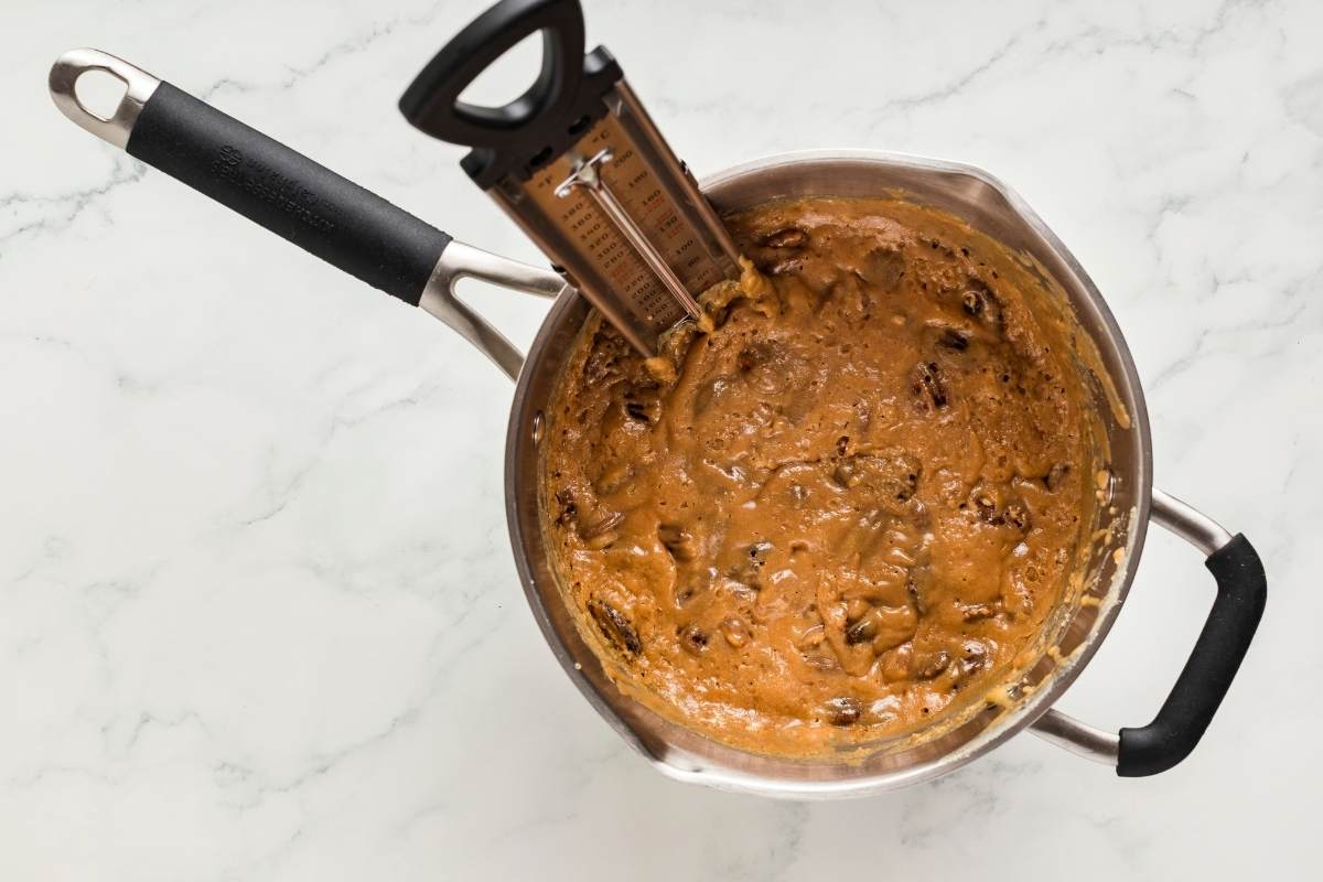 Candy thermometer in bubbling praline mixture.