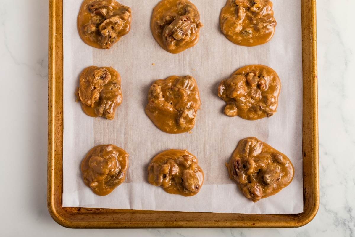 Pralines cooling on parchment-lined baking sheet.