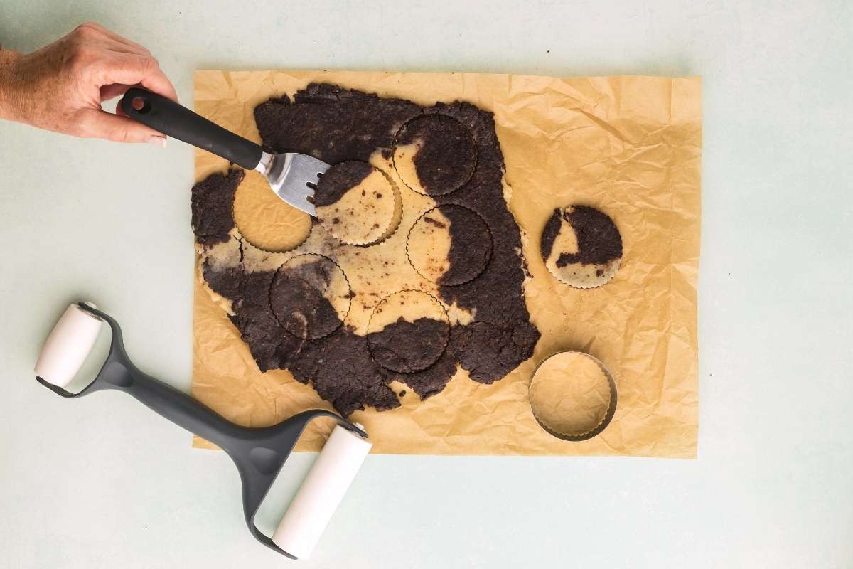 round cookies being cut out of dough.