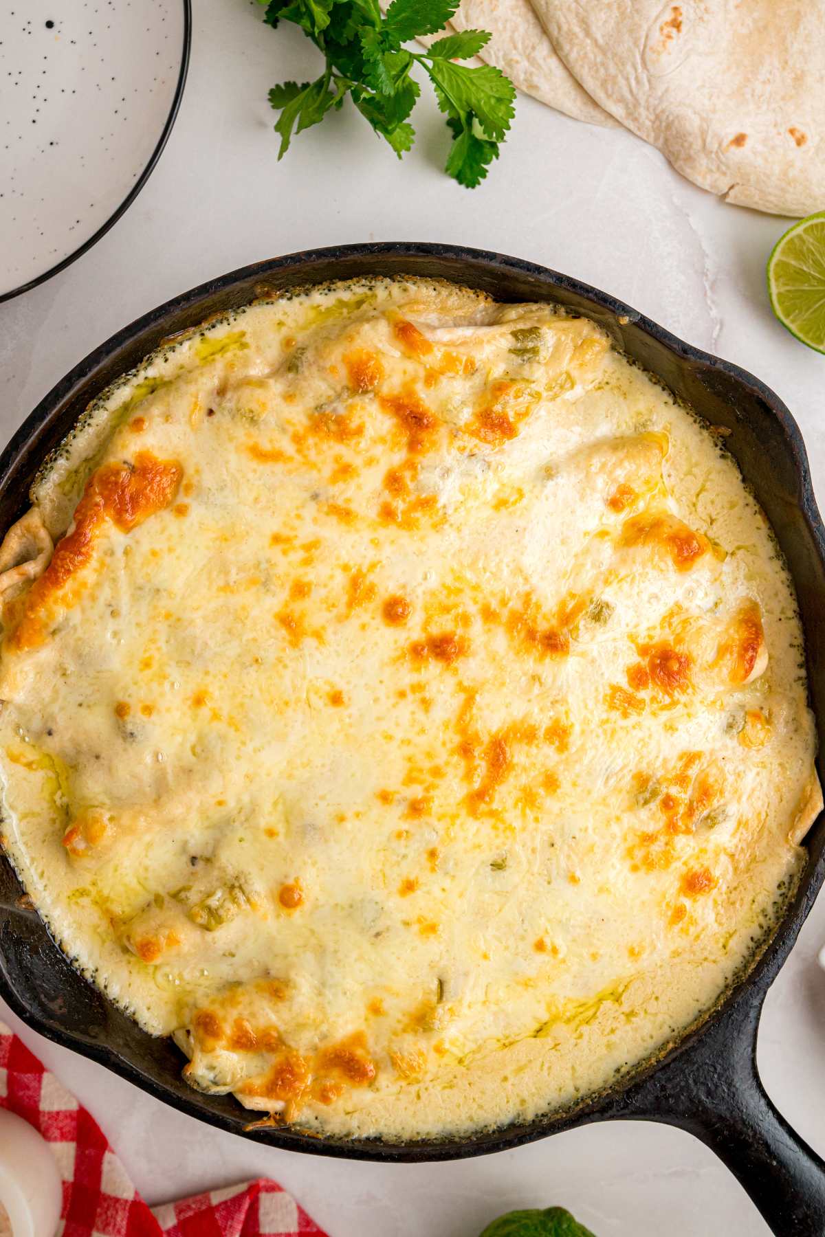 overhead view of enchiladas in cast iron skillet.