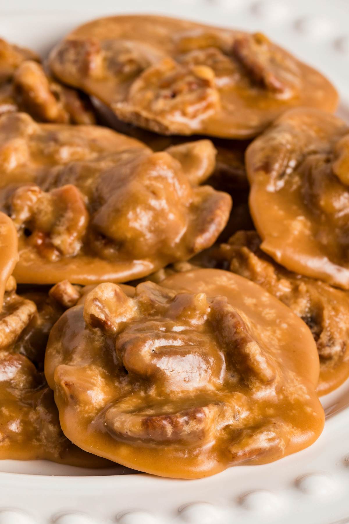 Close-up of glossy pralines showing pecans and smooth texture.