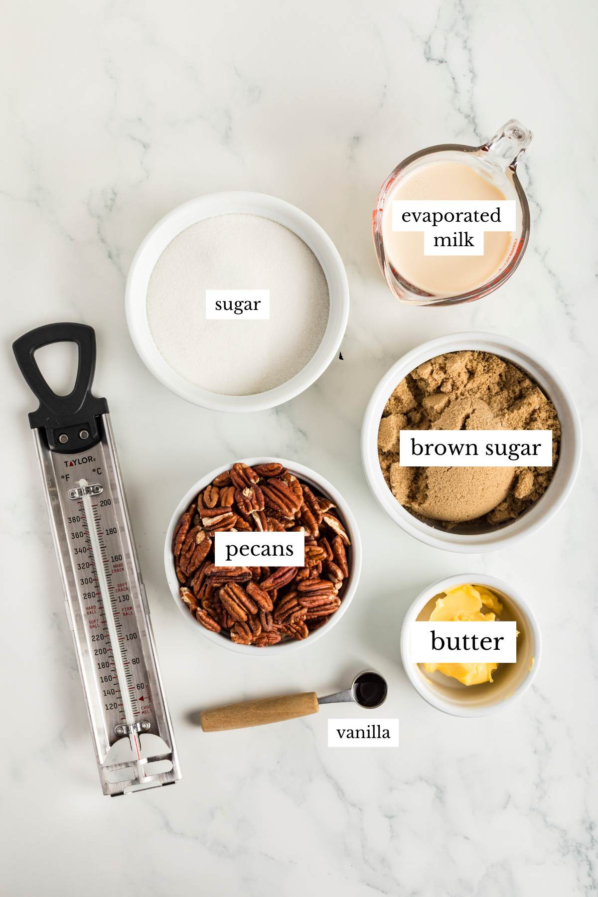 Bowls of sugar, brown sugar, pecans, butter, and evaporated milk on counter.