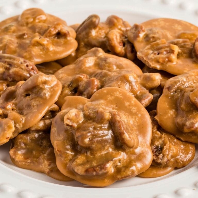 Pecan pralines stacked on white plate ready to serve.