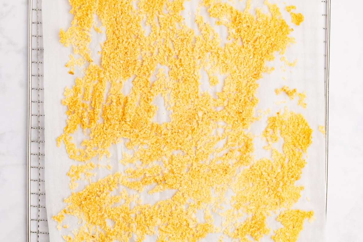 Chopped garlic spread on dehydrator tray with parchment.