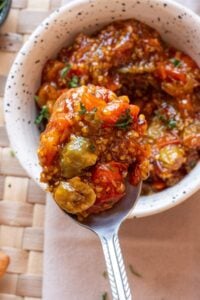 Bowl of tomato jam with herbs on top.