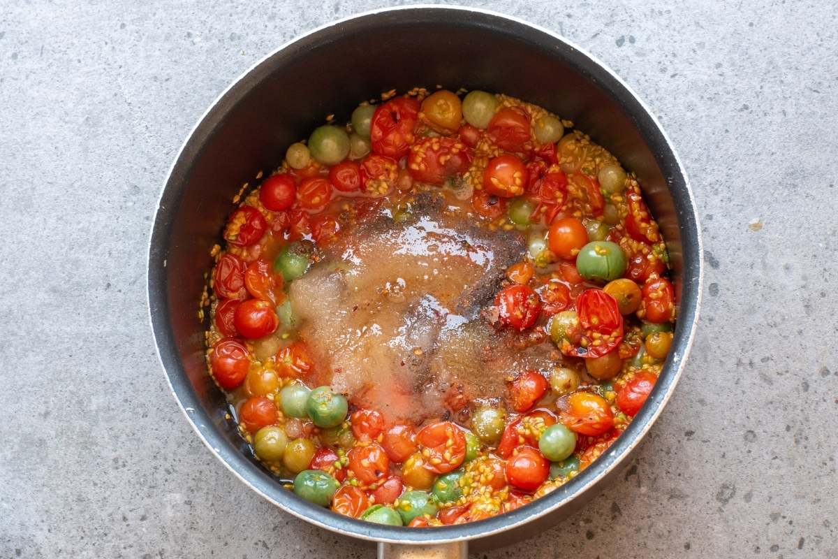 Tomatoes, sugar, and spices in pot before cooking.