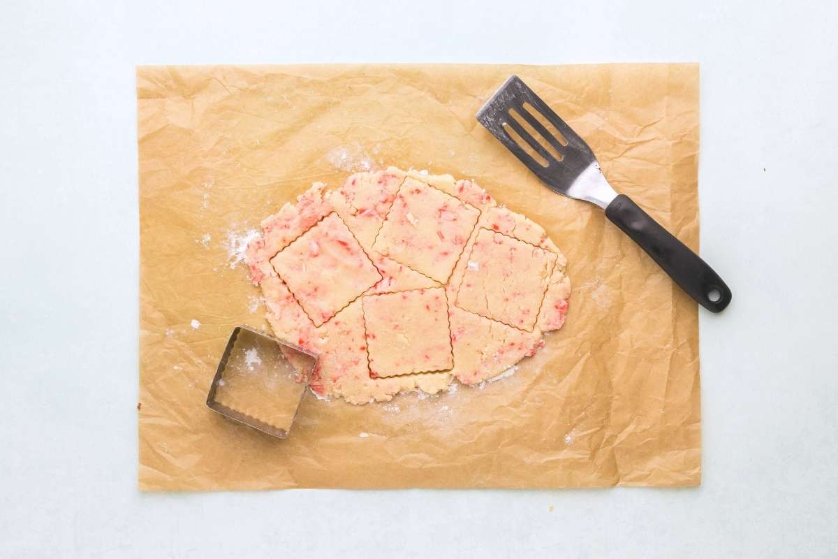 Peppermint dough rolled out and cut into squares with a cookie cutter.