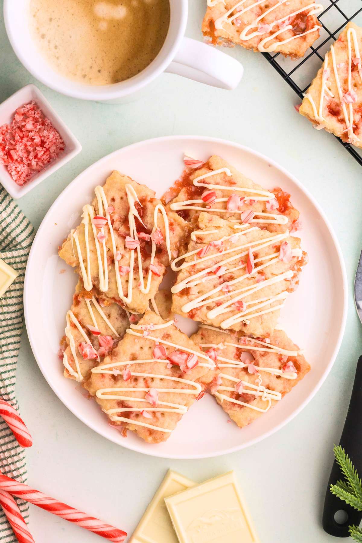 Plate of peppermint shortbread cookies drizzled with white chocolate.