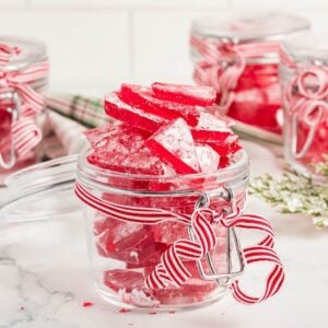 glass jar with shards of red candy on white background.