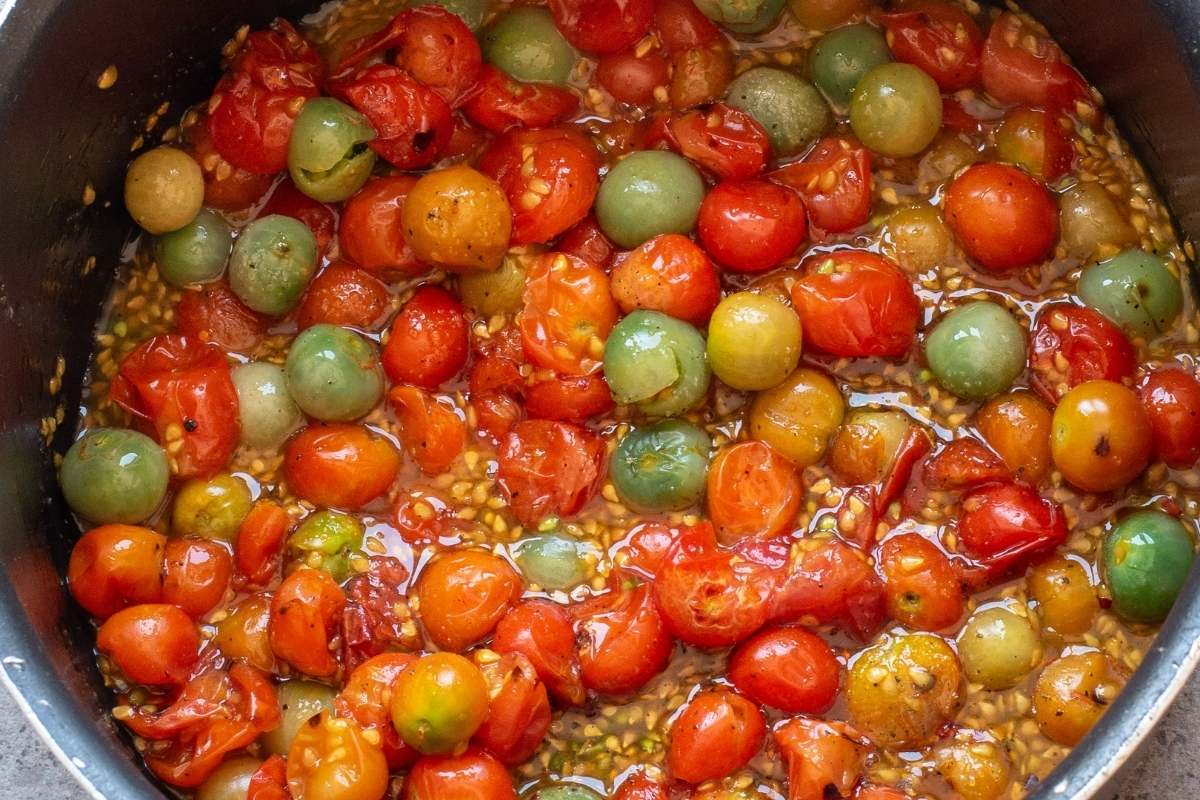 Tomatoes simmering in liquid in a pot.