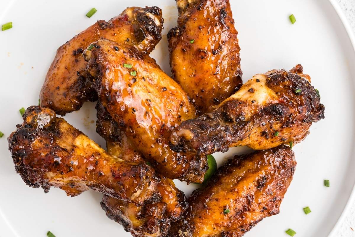 Overhead view of finished wings on a white plate.