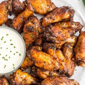 plated wings next to bowl of ranch.