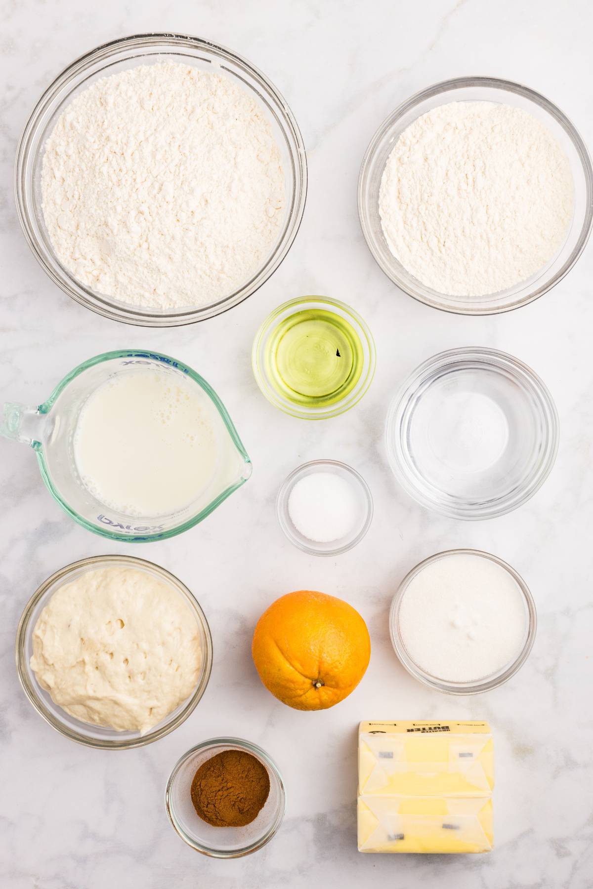 Baking ingredients measured and laid out on a marble counter.