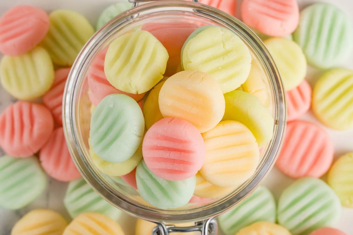 Pastel pink, green, and yellow cream cheese mints in a glass bowl.