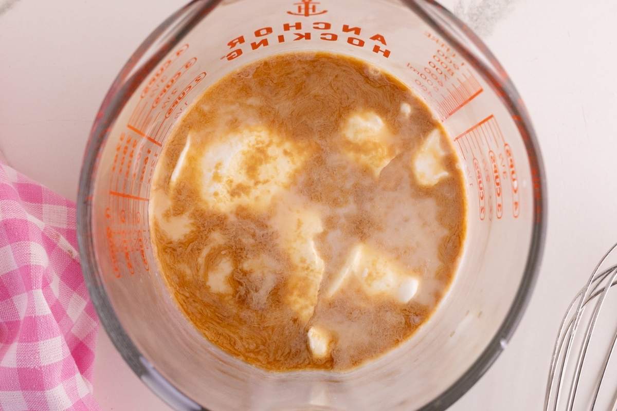 Cake flour, baking powder, salt, and baking soda in a mesh strainer over a bowl.