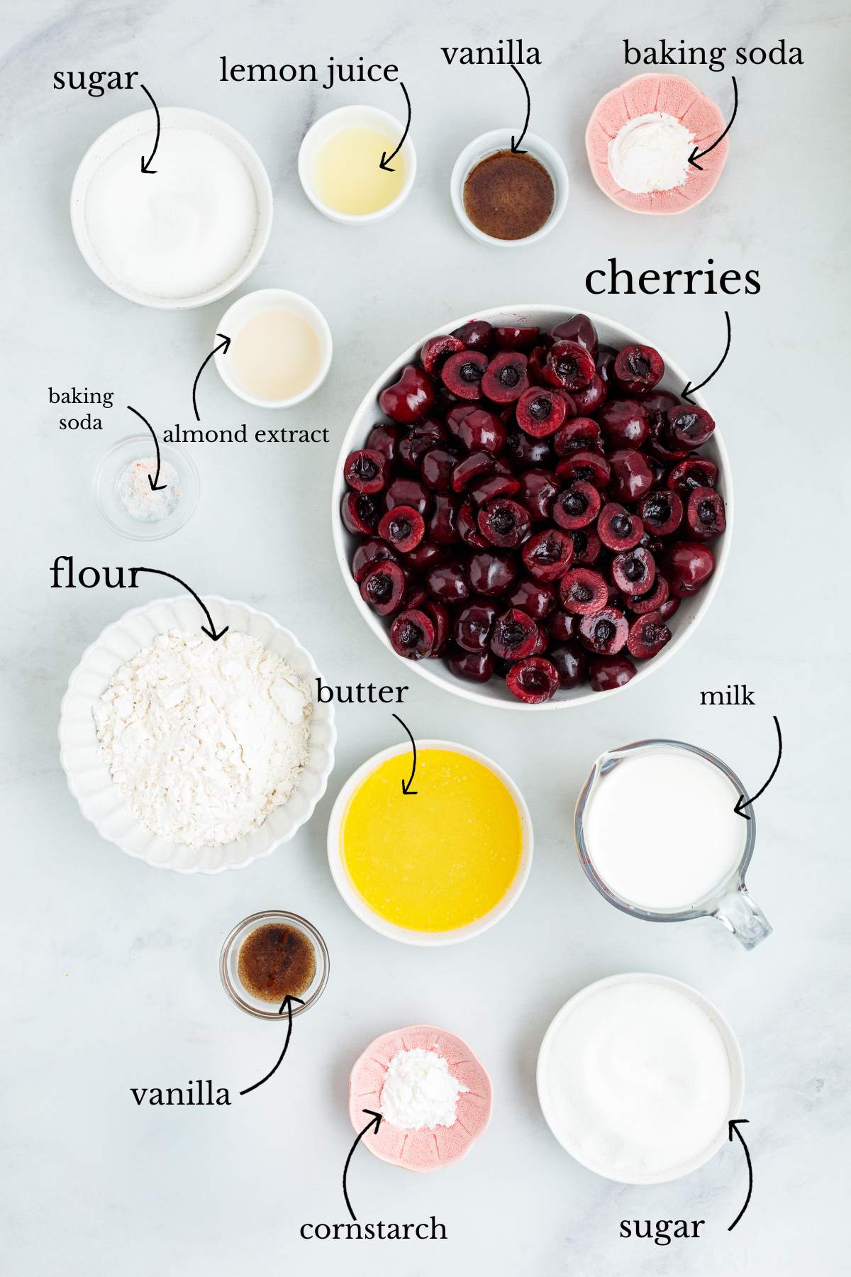 Raw ingredients for cherry cobbler arranged in small bowls with text labels.