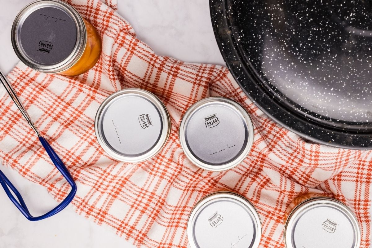 jars of peaches cooling on towel