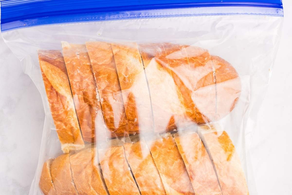 Frozen garlic bread slices in a clear plastic zipper bag.