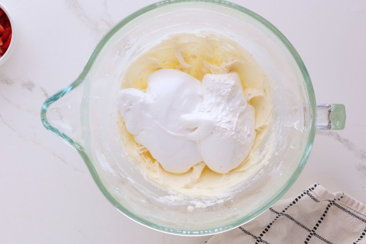 Marshmallow fluff in mixing bowl on top of butter 