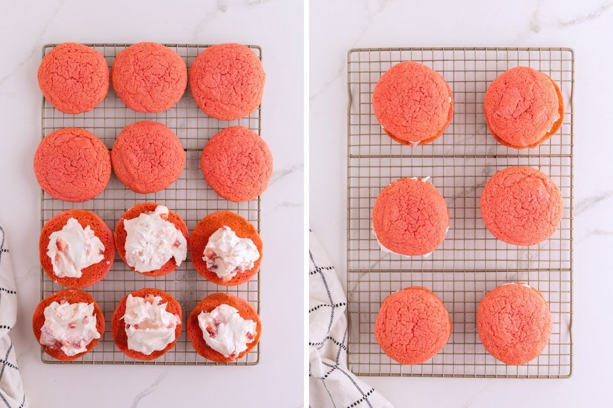 Pink strawberry cookies being filled with white cream frosting and assembled into whoopie pies on a cooling rack.