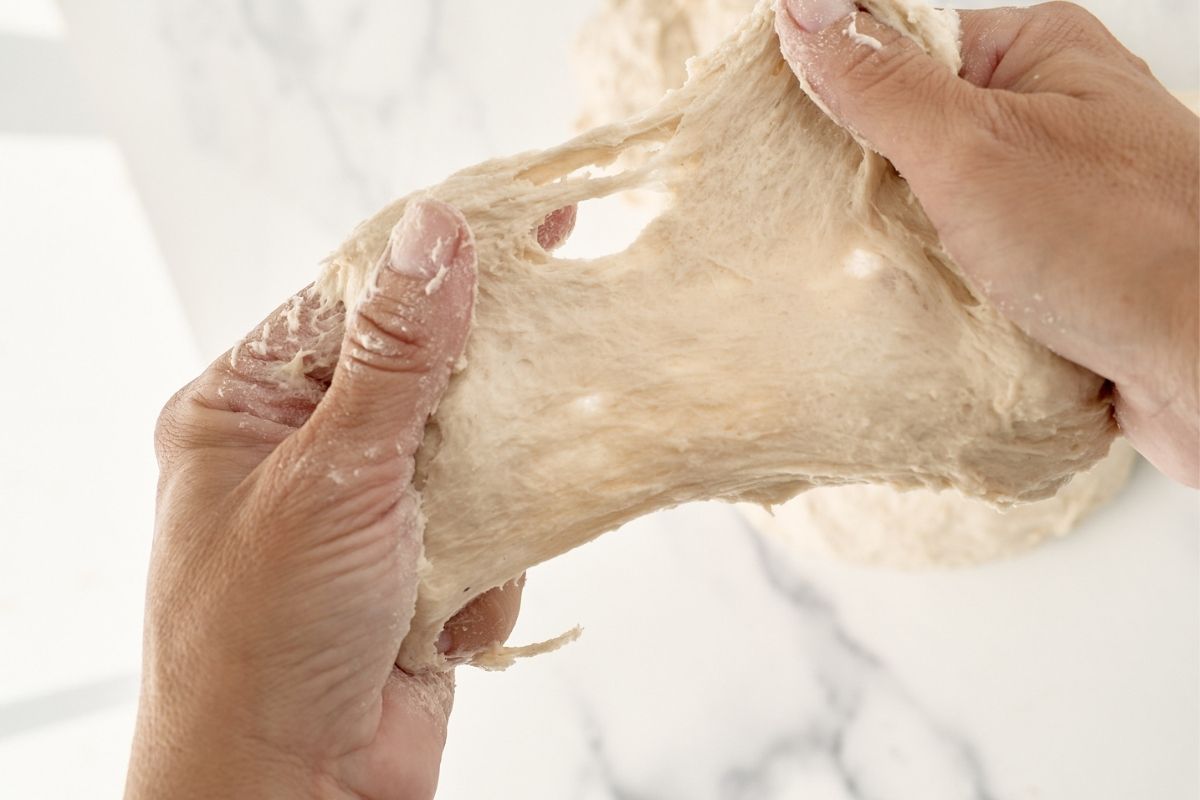 hands showing dough stretched out.