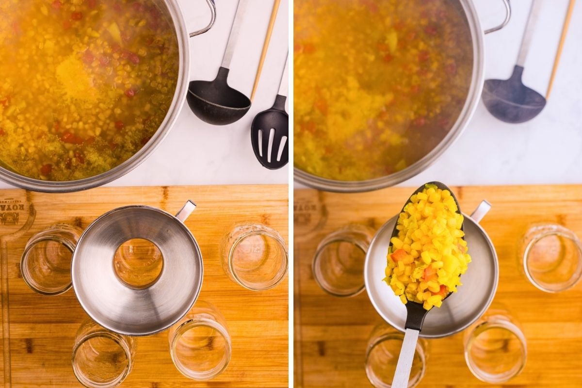 Yellow corn relish being ladled through a canning funnel into glass jars on a wooden board.