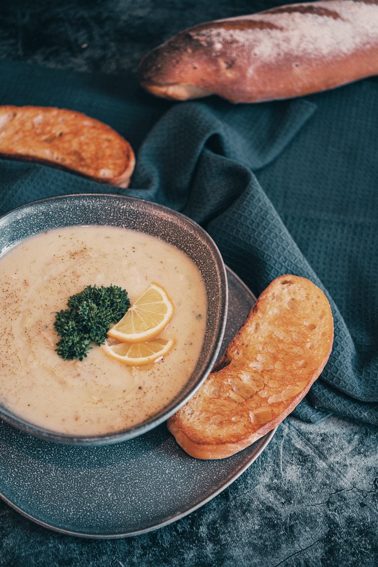 Warm creamy soup with lemon and parsley, served with crusty bread, perfect for cozy dining.