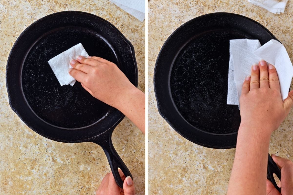 Hand rubbing oil into a cast iron skillet with a white paper towel to season.