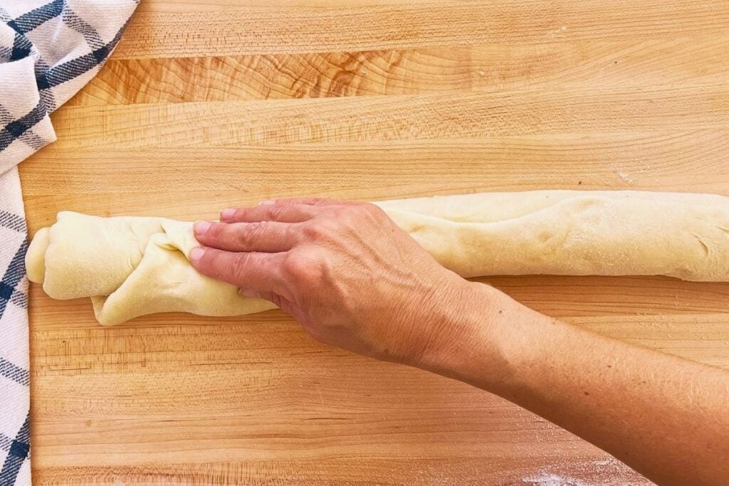rolled dough for buns that is being pinched the seal